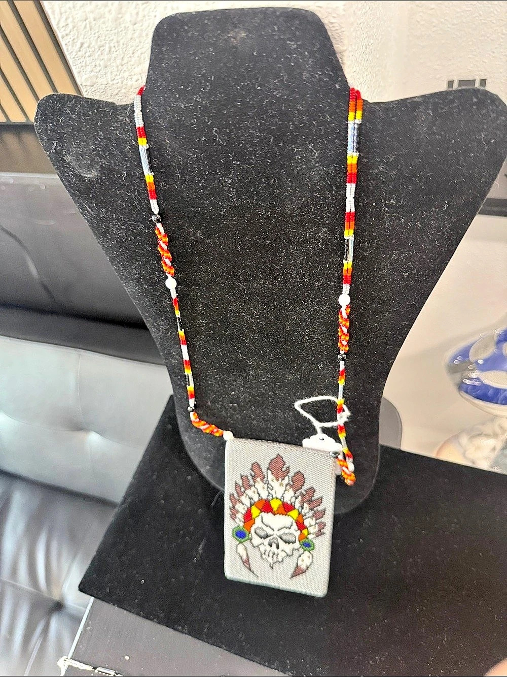 handcrafted beaded pendant featuring a detailed skull wearing a traditional feat